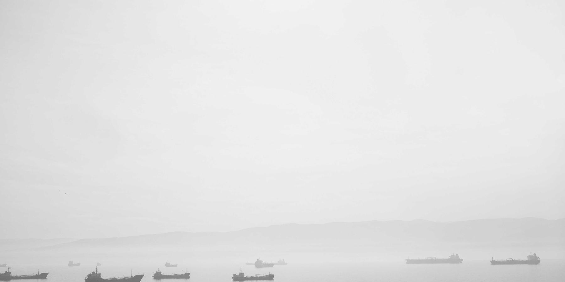 Ruhige graue See mit Schiffen am Horizont