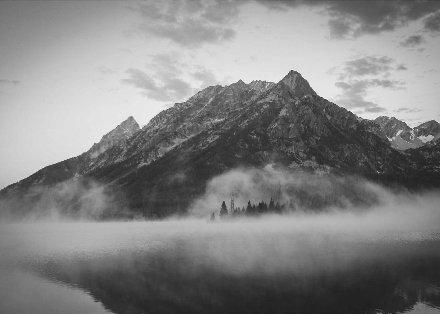 Ein Berggipfel über einem nebligen See